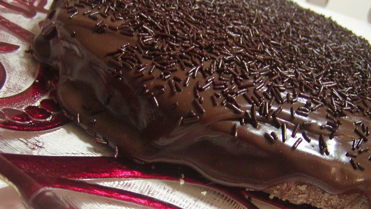 Bolo de chocolate fofo com cobertura de brigadeiro e granulado é especial